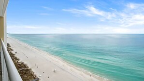 A beach view from a balcony with a clear sky and calm sea. - Majestic Beach Towers 1-1903 (Panama City Beach)