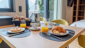 Una tavola per la colazione con croissant, succo d'arancia e una tazza di caffè.