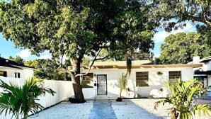 A pathway leading to a house with a white exterior, surrounded by gravel and small plants. - Quiet Miami Stay•Perfect for Work,Relax, or party! (Miami)