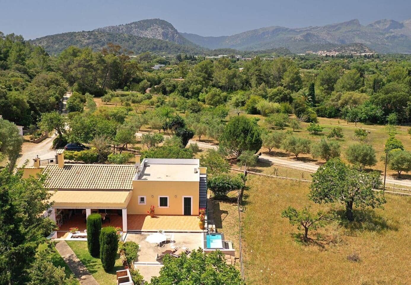 A two-story house with a tiled roof, a swimming pool, and a garden.