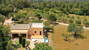 A two-story house with a tiled roof, a swimming pool, and a garden. - Villa Tirana (Pollença)
