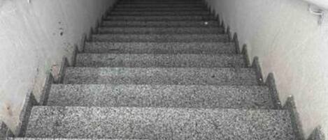 Una escalera con barandillas a ambos lados que conduce a un espacio interior.