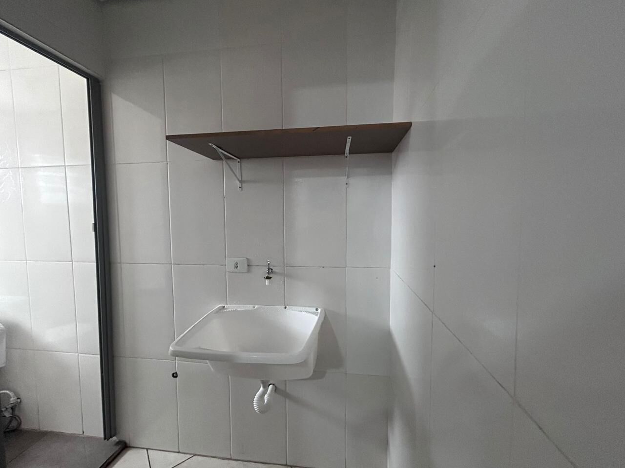A bathroom with a white sink, a mirror, and a shower area.