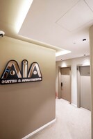 Un pasillo con un cartel que indica 'AIA Suites & Apartments' y dos puertas con las etiquetas '103' y '102'.