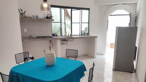 Una cocina con una mesa de comedor, sillas y un refrigerador.