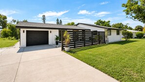 A single-story house with a garage, a fenced yard, and a well-maintained lawn. - Private Pool • 10 Min to Siesta Key Beach • Stylish Sarasota Retreat (Sarasota)