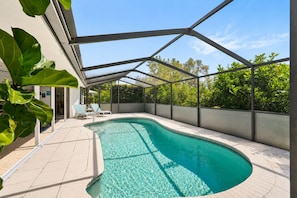 Una piscina con acqua cristallina, circondata da un portico coperto con lettini.