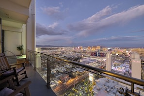 A balcony with a view of a cityscape, including a prominent building with 'PALMS' signage.