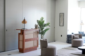 A modern living room with a wooden console table, a potted plant, and a grey sofa. - A+ Location • Hot Tub & Strip Views • Gym & Pool (Las Vegas)