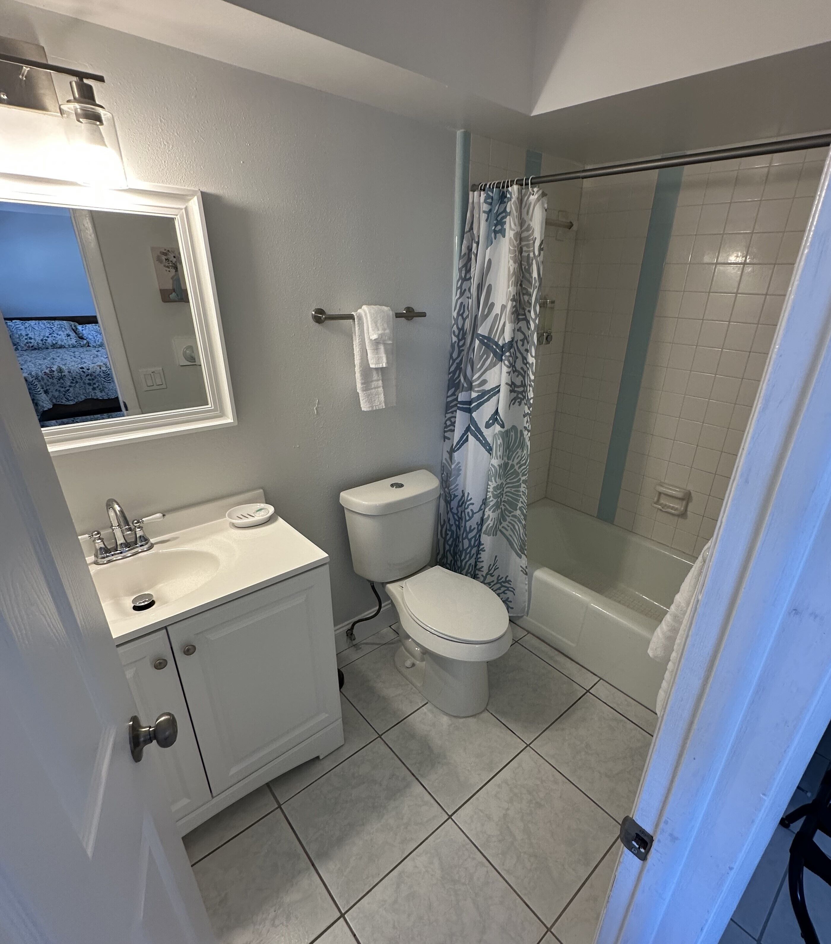A bathroom with a toilet, sink, and shower.
