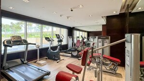 A modern gym with treadmills, elliptical machines, and weight equipment.
