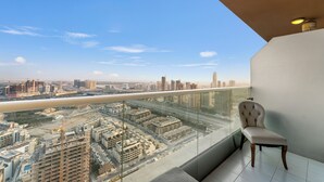 A balcony with a city view, a chair, and a modern ceiling light.