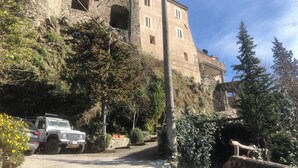 A stone building with multiple windows and a paved road in front. - Cà La Torre, Stone House with pool in the terrace and super view (Bibola)