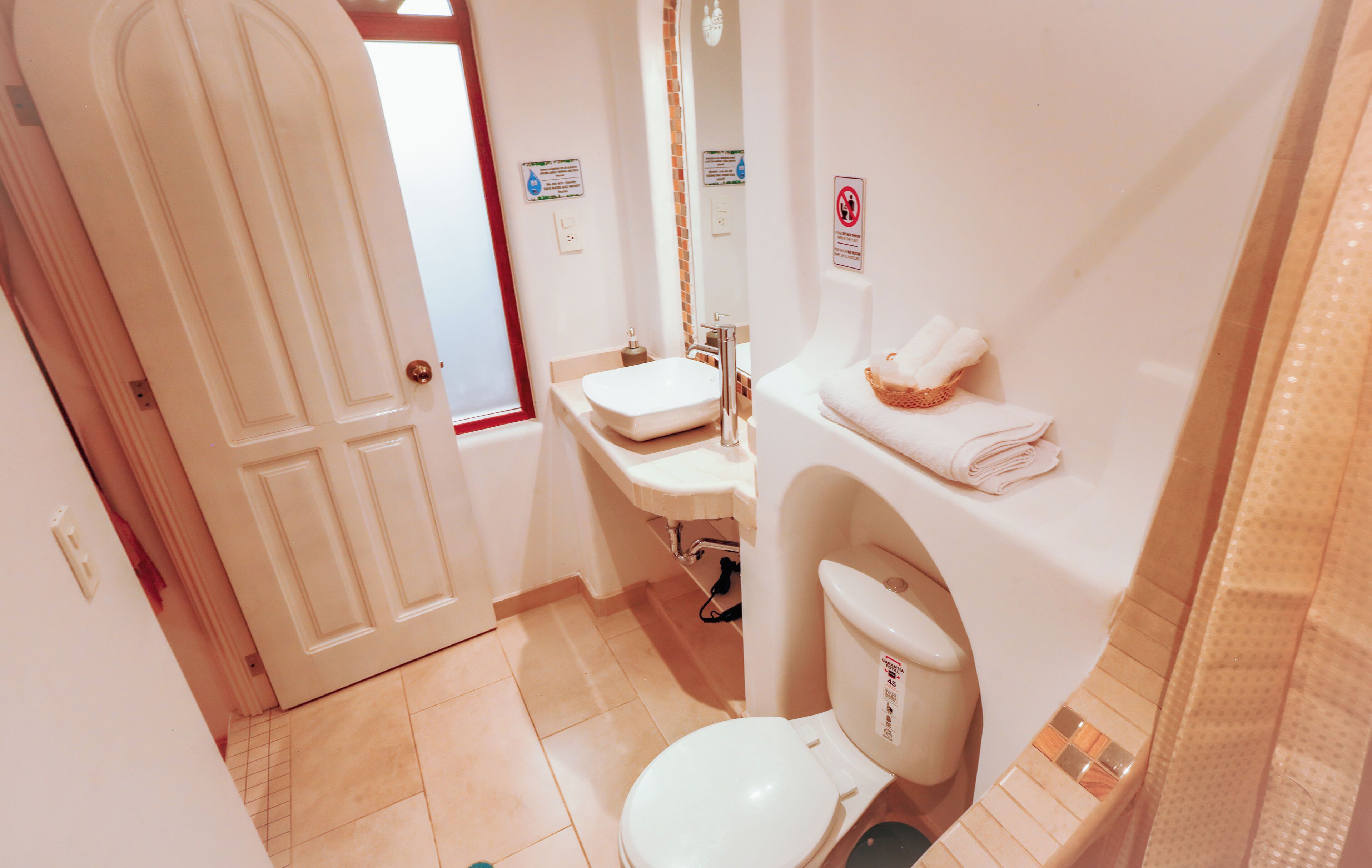 A bathroom with a toilet, sink, and towel rack.