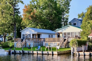 A waterfront house with a dock, a covered porch, and a small deck. - Spacious 5 BR House on the River (Indian River)