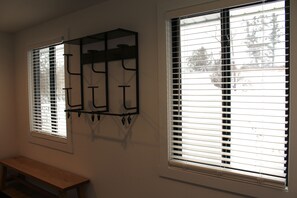 Two windows with blinds, a wooden bench, and a wall-mounted rack. - Spacious 5 BR House on the River (Indian River)