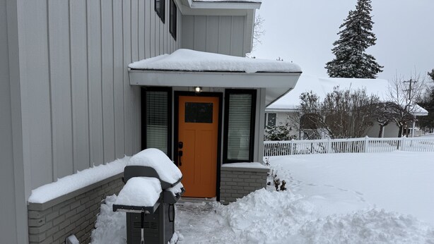 A residential house with a snow-covered front door and a snow blower in front. - Spacious 5 BR House on the River (Indian River)