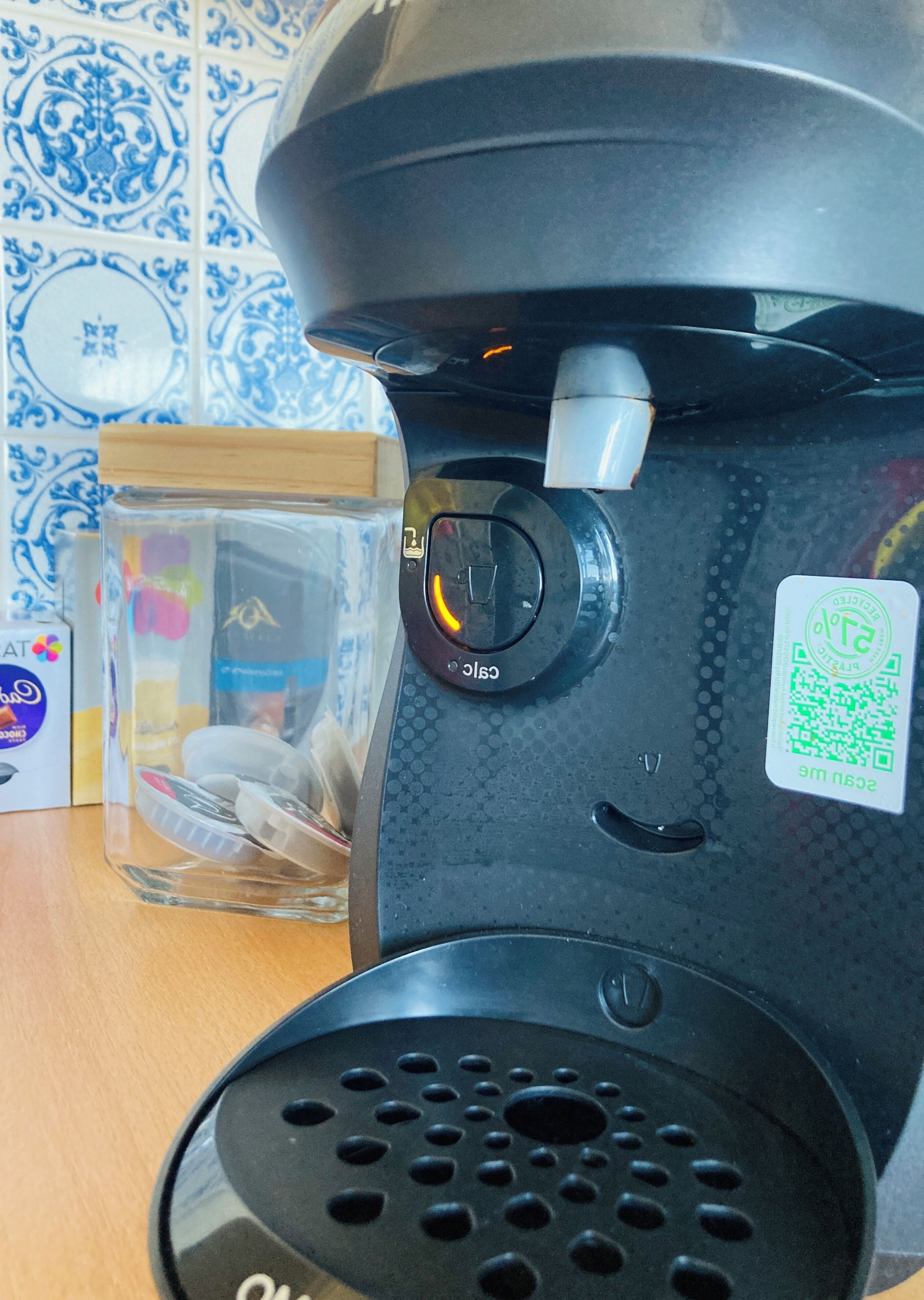 Eine Kaffeemaschine mit einem Glas Milch und einer Tasse Kaffee auf einem Tisch.
