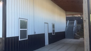 Un edificio con un ingresso coperto, una porta e una scalinata che vi conduce all'interno.