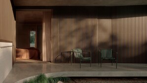 Un intérieur moderne avec un lit, deux fauteuils et une grande fenêtre.