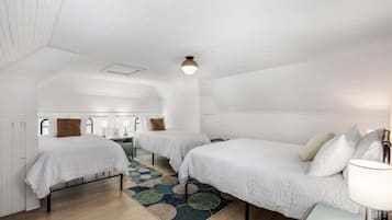 A room with two beds, a patterned rug, and a ceiling light.