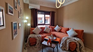 A cozy living room with a sofa, a coffee table, and a floor lamp. - Cosy apartment in the heart of the medina (Marrakech)
