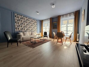 A modern living room with a sofa, chairs, a coffee table, and a patterned wall.