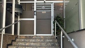 A staircase with metal railings, a metal door, and a potted plant. - AP Smart Hub Agro (Piracicaba)