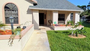 A single-story house with a front porch, a small garden, and a clear sky. - Tranquil studio with AC in quiet Merritt Island neighborhood (Merritt Island)