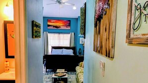 A hallway leading to a bedroom with a bed, a ceiling fan, and a 'Welcome' sign. - Tranquil studio with AC in quiet Merritt Island neighborhood (Merritt Island)