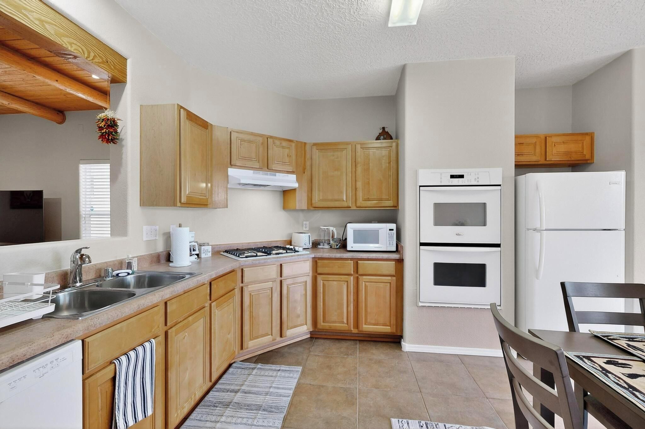 A compact kitchen with wooden cabinets, a microwave, a stove, and a refrigerator.