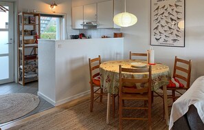 Una cocina acogedora con una mesa redonda, sillas de madera y una lámpara colgante.