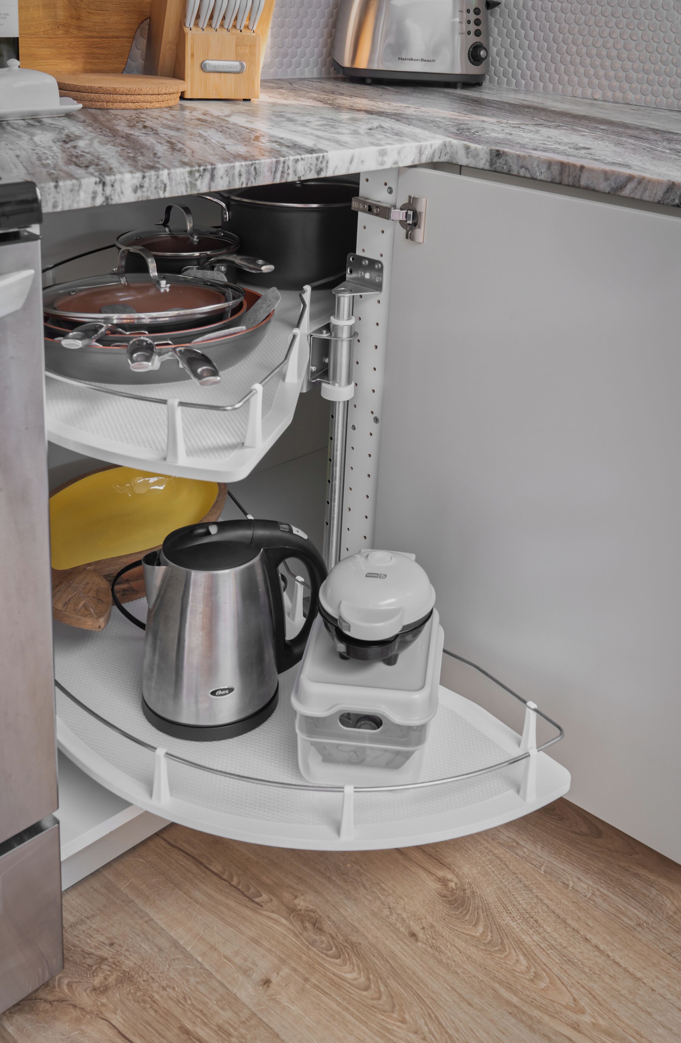 A kitchen with a built-in shelf unit holding cookware, a kettle, and a rice cooker.