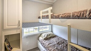 A bunk bed room with a window, a white cabinet, and a small shelf. - The Cottages and Suite · Poconos Escape (Pleasant Mount)