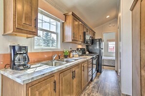 A kitchen with wooden cabinets, a stainless steel sink, a coffee maker, and a microwave. - The Cottages and Suite · Poconos Escape (Pleasant Mount)