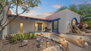 A modern house with a white exterior, blue accents, and a desert garden with cacti and rocks. - La Encantada Luxe Desert Retreat (Tucson)