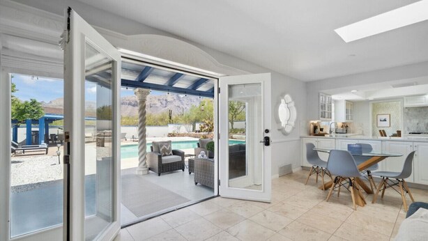 An open-plan living area with a patio, a dining table, and a kitchen. - La Encantada Luxe Desert Retreat (Tucson)