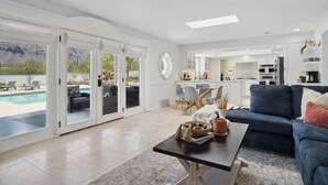 A spacious living room with a pool view, a dining area, and a kitchen. - La Encantada Luxe Desert Retreat (Tucson)