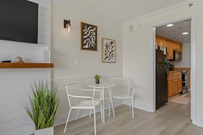 Eine moderne Küche mit Holzausstattung, einem Edelstahlkühlschrank und einer Mikrowelle.