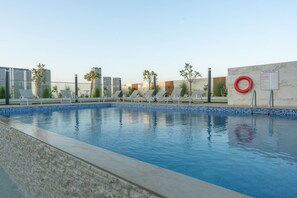 A swimming pool with lounge chairs, a lifebuoy, and a signboard. - JVC Sleeps 4 With Private Balcony (Dubai)