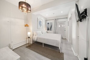 Un dormitorio moderno con cama, mesita de noche, lámpara y candelabro.