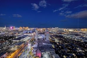 A cityscape at night with prominent buildings, including a casino with a large sign and a tower.