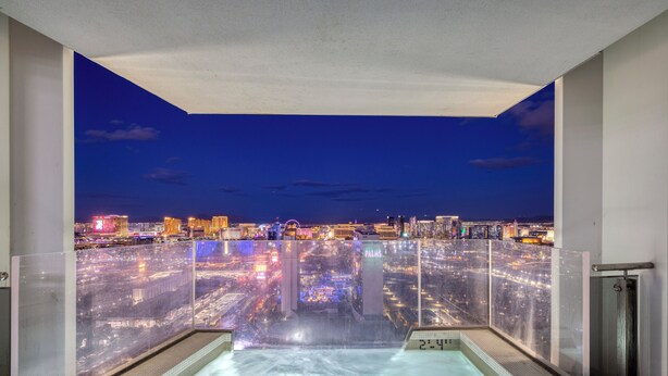 Une piscine à d ébordement située sur le toit, offrant une vue sur la ville au crépuscule.
