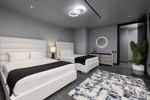 Een moderne slaapkamer met twee bedden, een nachtkastje, een spiegel en een potplant.
