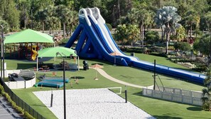 Parque acuático con varias toboganes y un pabellón con techo verde.