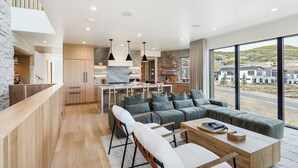 Uma cozinha moderna com parede de pedra decorativa, armários de madeira e uma ilha central.