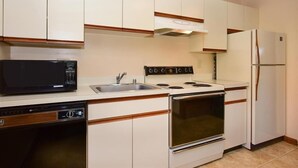 A kitchen with white cabinets, a black microwave, a stove, a dishwasher, and a refrigerator. - Deluxe 1BR w/ Patio | Golf Nearby + Resort Pools (Champion)