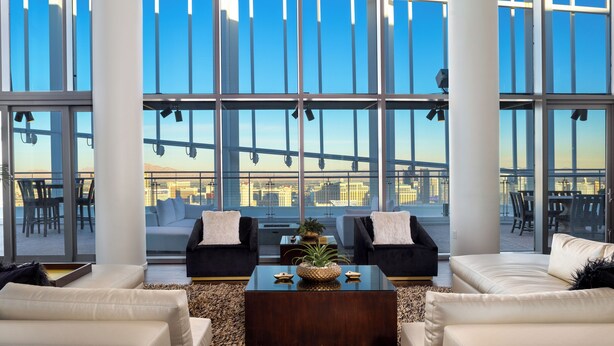 Un amplio salón con ventanas grandes, una mesa de centro moderna y asientos cómodos.