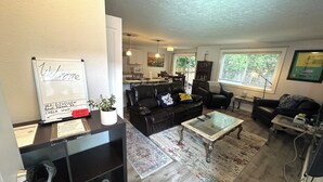 A living room with a whiteboard, black leather sofas, a glass coffee table, and a rug. - LUXURY GOLF GETAWAY DOWNTOWN BOISE (Boise)