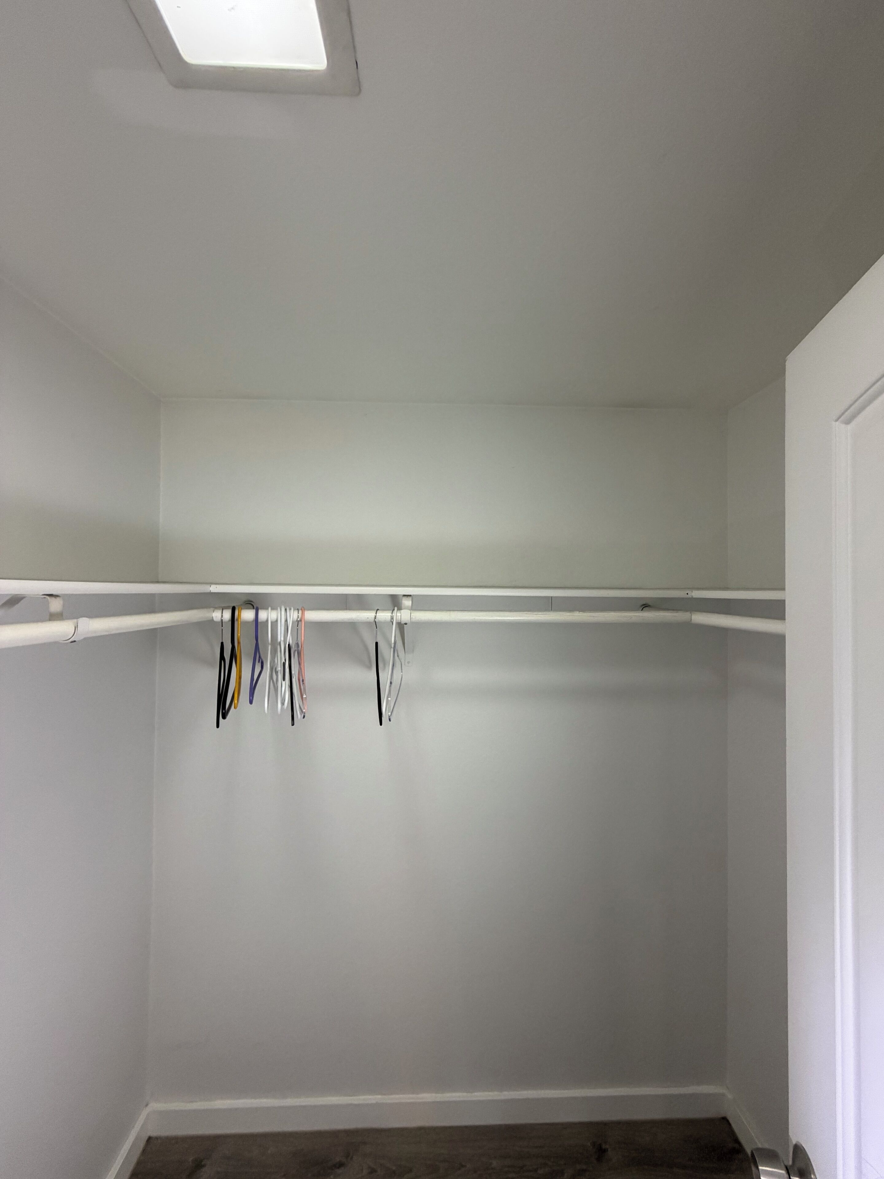 Una habitación con un armario blanco, una puerta blanca y un techo blanco.